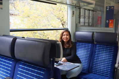 Portrait of smiling woman sitting in train