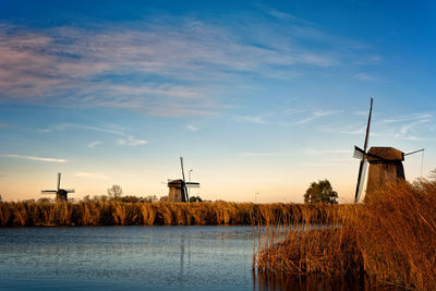 Traditional windmill against sky at sunset