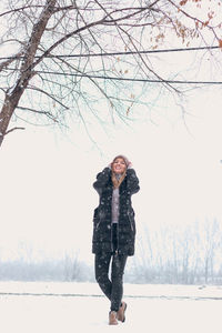 Portrait of man on snow covered tree