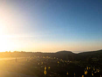 Scenic view of field against clear sky during sunset