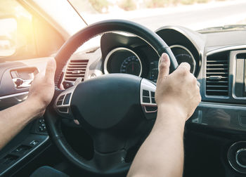 Cropped hands of man driving car