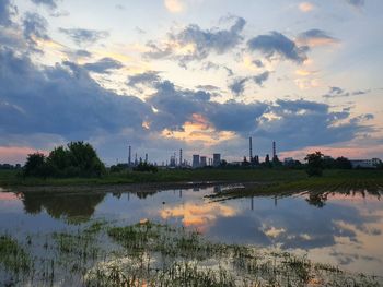 Panoramic view of factory against sky during sunset