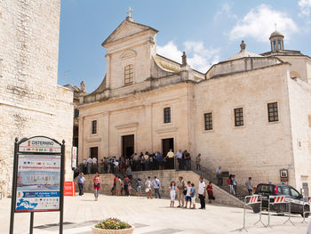 People in front of cathedral against sky