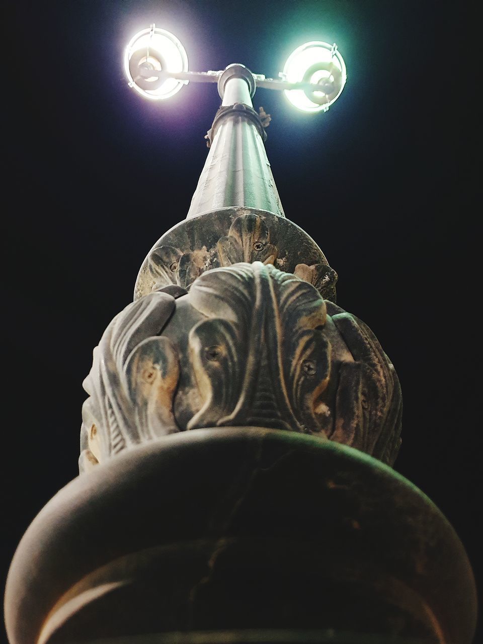 LOW ANGLE VIEW OF STATUE AGAINST ILLUMINATED LIGHT