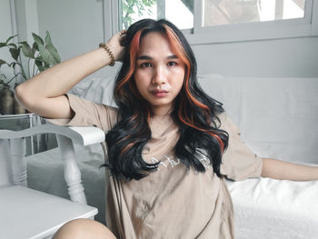 Portrait of young woman sitting at home