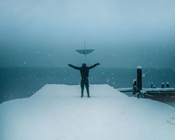 Rear view of person standing on snow covered landscape