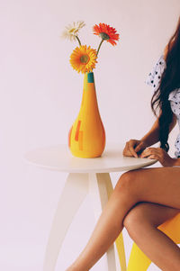 Close-up of yellow flowers in vase on table