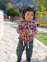 Full length of cute baby boy standing on footpath