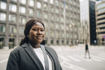 Portrait of smiling businesswoman in city