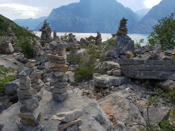 Stone wall by rocks against sky