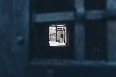 Abandoned building seen through tunnel gate