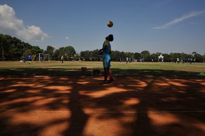 Man playing soccer on field against sky