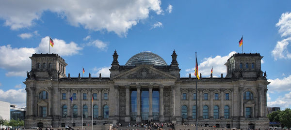 Facade of building against cloudy sky