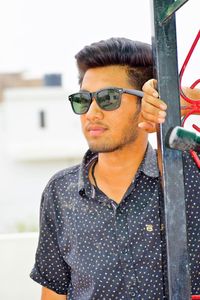 Portrait of young man wearing sunglasses standing outdoors