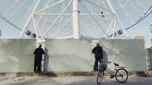 People standing on bicycle against sky