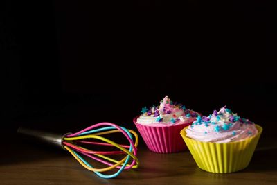 Multi colored cupcakes against black background