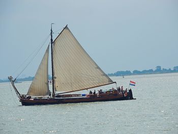 Boat sailing on sea against clear sky