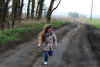 Full length of girl running on road