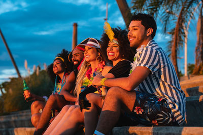 Smiling friends sitting outdoors