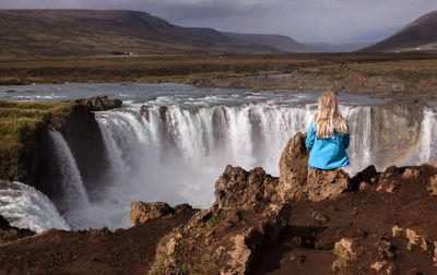 Rear view of woman looking at waterfall