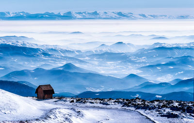 Scenic view of snowcapped mountains against blue sky