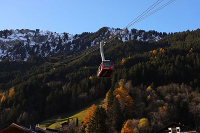 Overhead cable car over mountains against sky