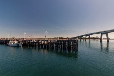 Bridge over sea against clear sky