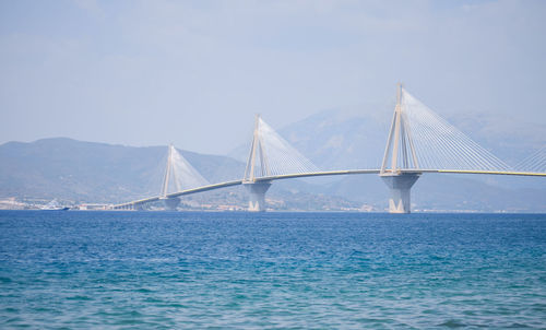 Cable-stayed bridge over bay against clear sky