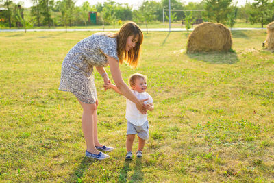 Full length of mother and daughter on grass