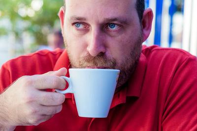 Close-up of man drinking coffee at outdoor cafe