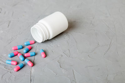 Close-up of pills spilling from bottle