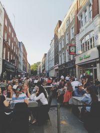 People on street amidst buildings in city