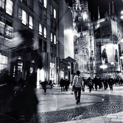 People walking on city street at night