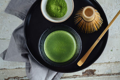 High angle view of cup of green tea on table