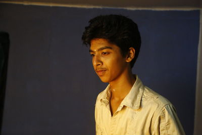 Smiling young man standing against gray background