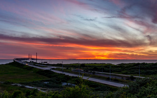 Scenic view of bridge over sea against sky during sunset