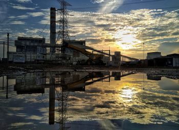 Bridge over river against sky during sunset