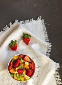 Bowl of healthy fresh fruit salad on white background. top view