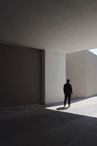 Rear view of man standing against wall