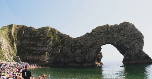Scenic view of rock formation in sea against clear sky
