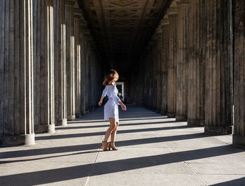 Side view of woman standing at colonnade