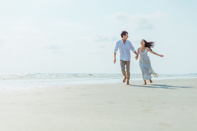 Full length of woman on beach against sky