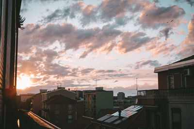 Buildings in city against sky during sunset