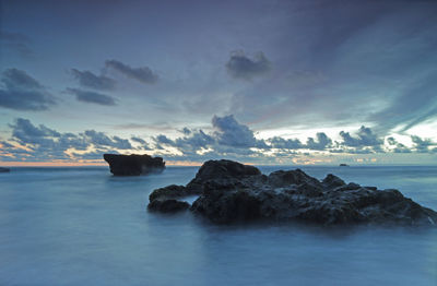 Rocks on sea shore against sky