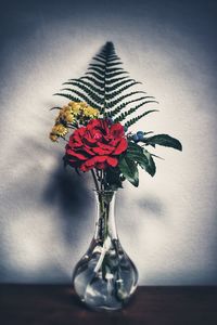 Close-up of red flower vase on table against wall