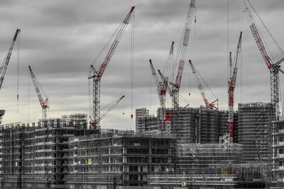 Cranes at construction site against sky