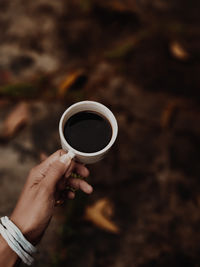 Cropped hand holding coffee cup