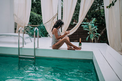 Woman sitting on swimming pool