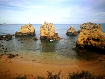 Rocks on beach against sky