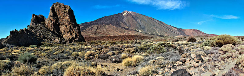 Scenic view of mountains against blue sky